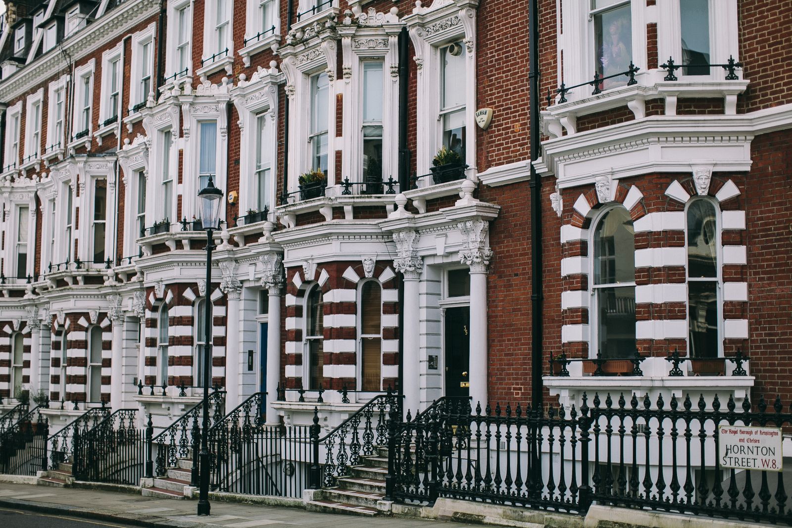 A row of Victorian terraced townhouses on a quiet residential London street